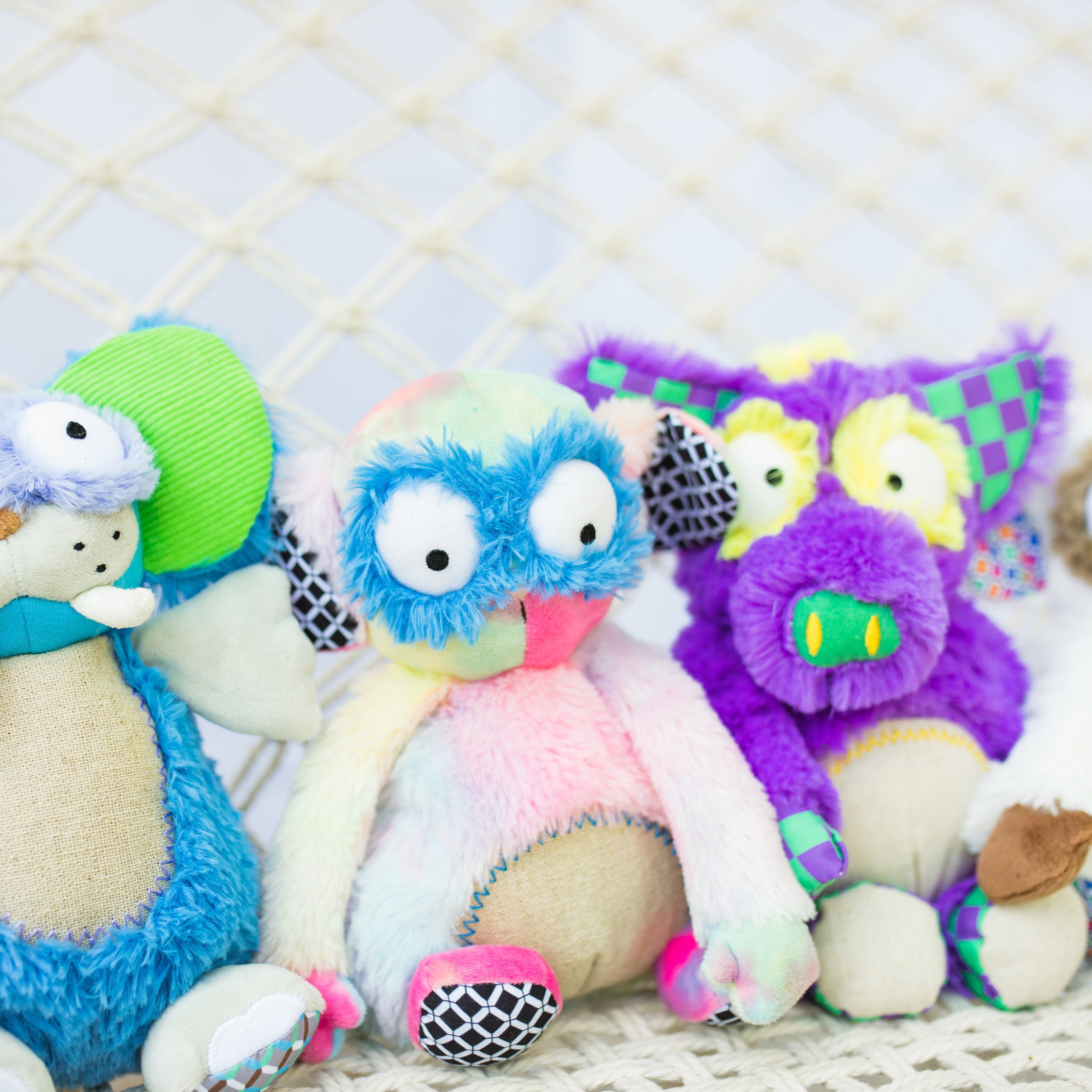 Colorful plush toys with googly eyes on a textured surface